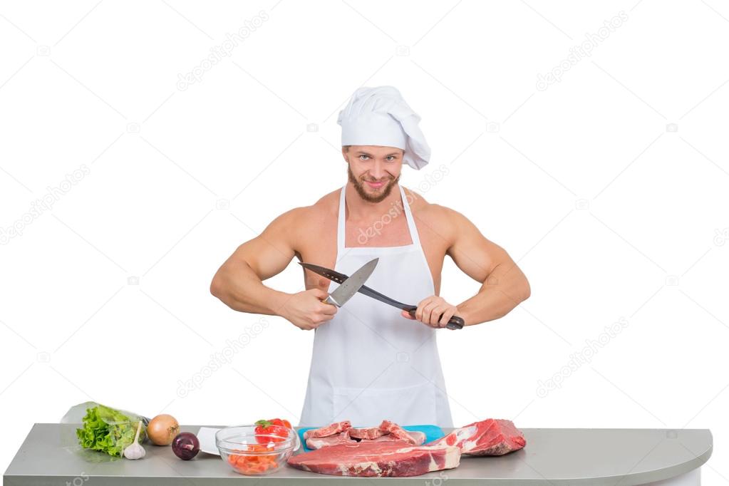 Chef bodybuilder preparing large chunks of raw meat. Stock Photo by