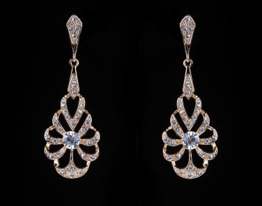 gold earrings with jewels on the black
