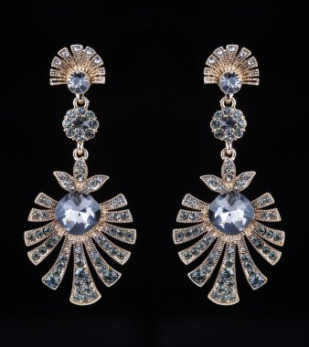 gold earrings with jewels on the black