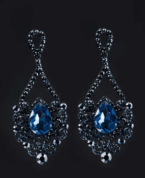 Earring with colorful blue gems on black background — 스톡 사진