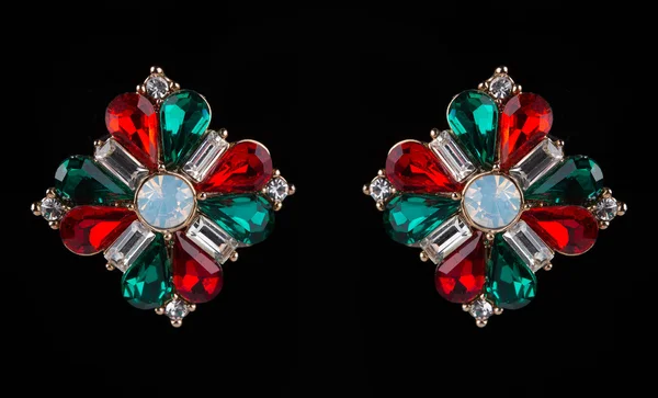 Earring with colorful red and green gems on black background — Stock Fotó