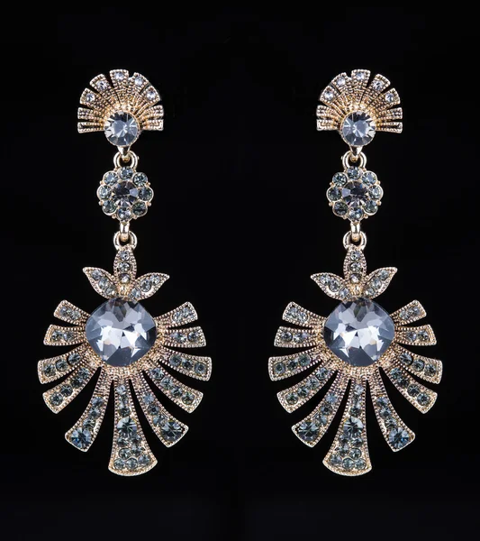 Gold earrings with jewels on the black — 图库照片