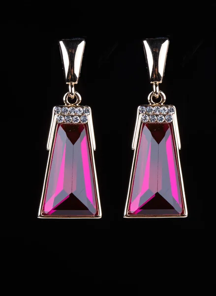 Earring with colorful pink gems on black background — Stock Photo, Image