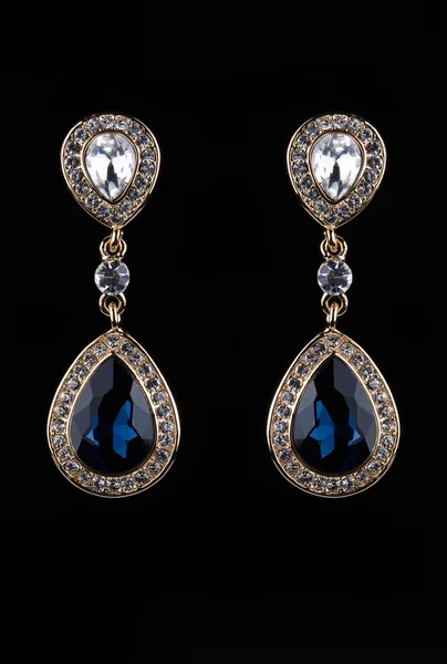 Earring with colorful blue gems on black background — 스톡 사진