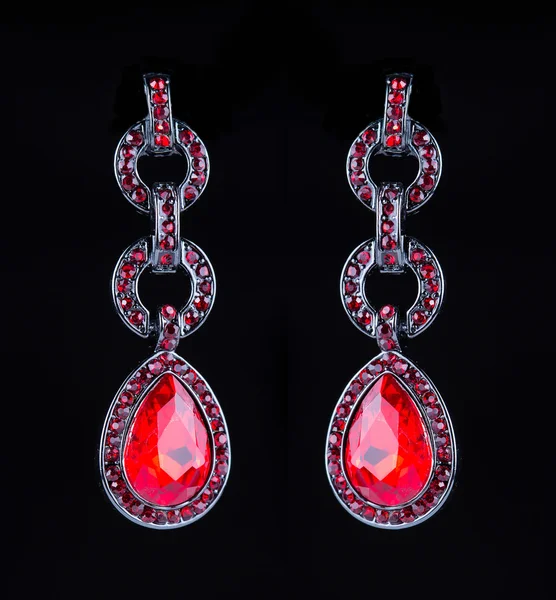 Earring with colorful red gems on black background — Stock Photo, Image