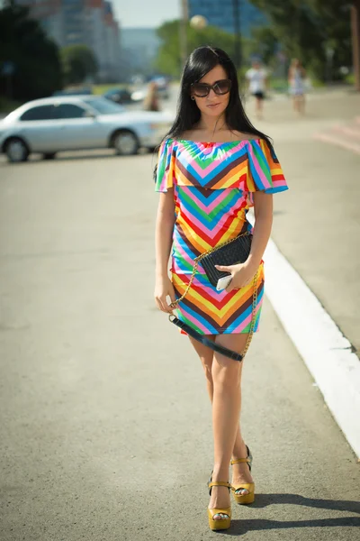 Girl in colorful dress and sunglasses on the street — Stok fotoğraf