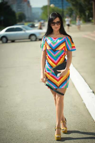 Chica en vestido colorido y gafas de sol en la calle — Foto de Stock