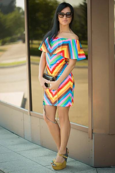 Chica en vestido colorido y gafas de sol en la calle — Foto de Stock