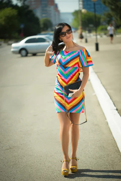 Girl in colorful dress and sunglasses on the street — Stock Photo, Image