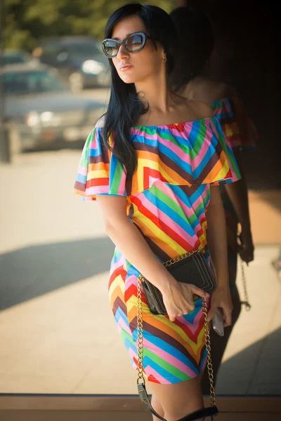 Fille en robe colorée et lunettes de soleil dans la rue — Photo