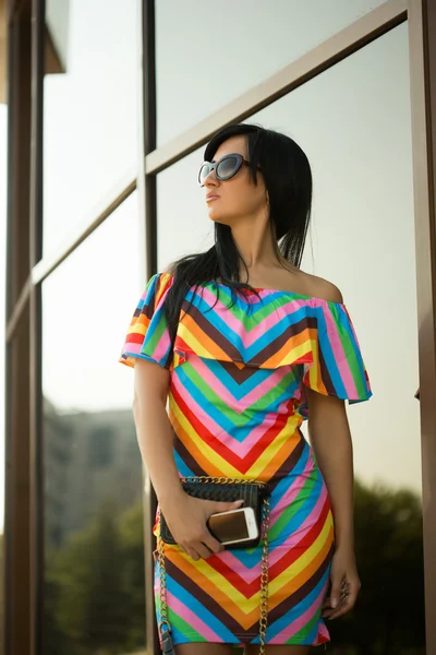 Girl in colorful dress and sunglasses on the street — Stok fotoğraf