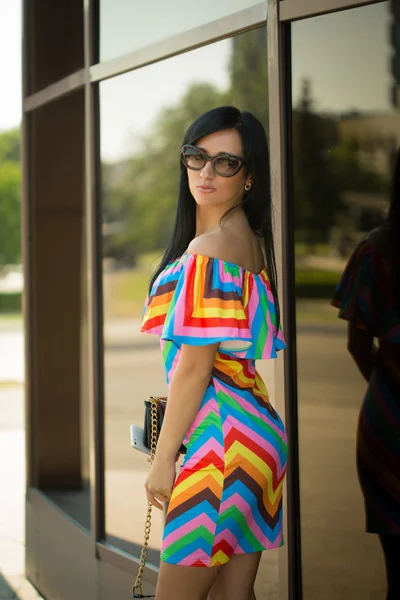 Girl in colorful dress and sunglasses on the street — Stock Photo, Image