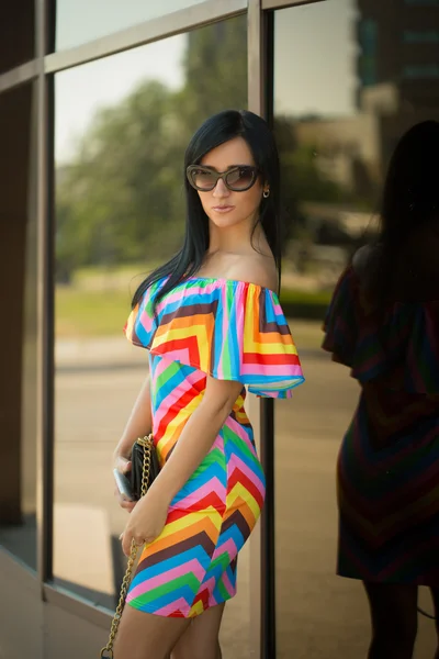 Gadis dengan gaun berwarna-warni dan kacamata hitam di jalan — Stok Foto