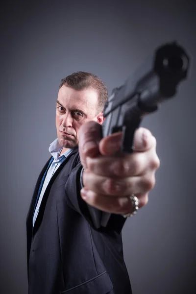 Un hombre con un traje de negocios con un arma — Foto de Stock