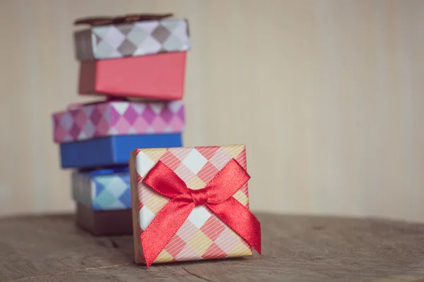 Caja de regalo con lazo rojo sobre fondo de madera —  Fotos de Stock
