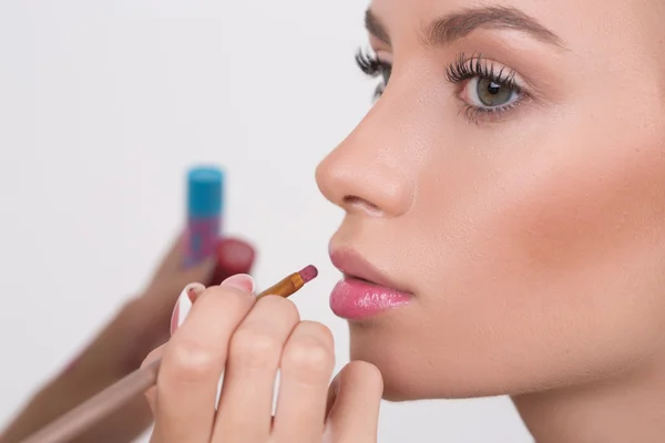 Maquillaje artista aplica lápiz labial. Hermosa cara de mujer . —  Fotos de Stock