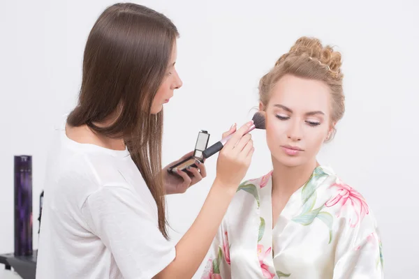 Maquiagem artista na aplicação de blush nas bochechas com escova de blush — Fotografia de Stock