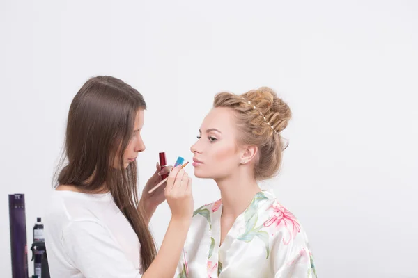 Make-up artiest geldt lippenstift. Mooie vrouw gezicht. — Stockfoto