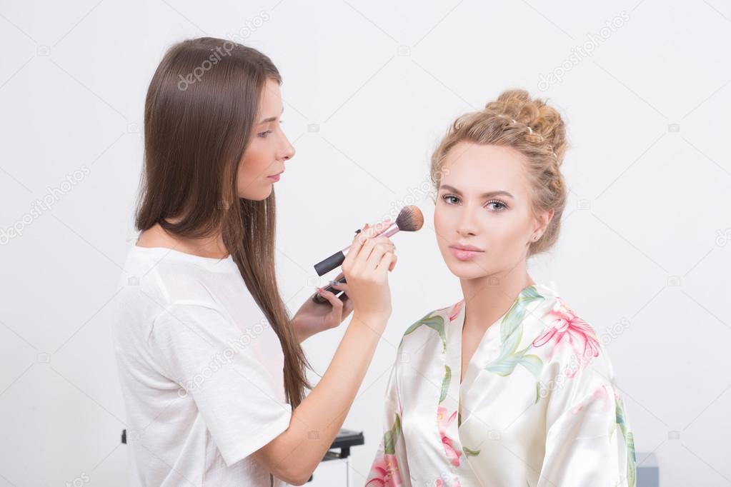 Makeup artist on applying blush on cheeks with blush brush