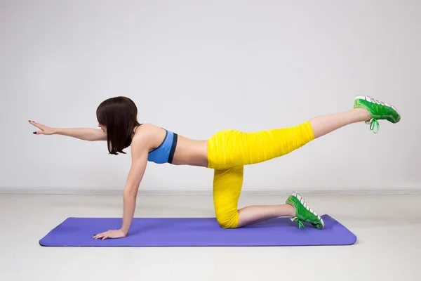 Chica atlética, ejecutar ejercicio sobre los músculos del vientre y la sonrisa —  Fotos de Stock