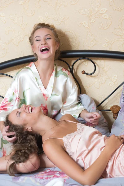 Friendship - two smiling girls have Gossip,white bed — Stock Photo, Image