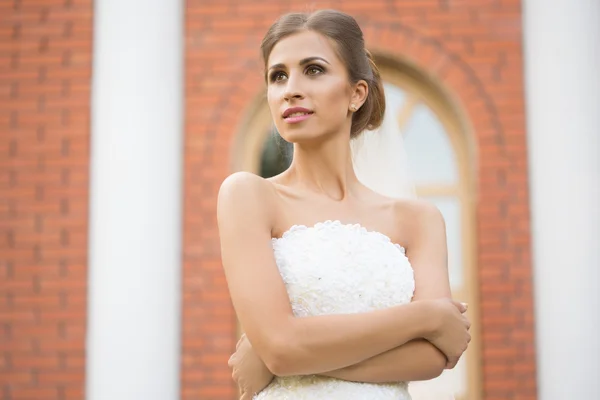 Nevěsta na pozadí cihlovou zeď. svatební šaty — Stock fotografie