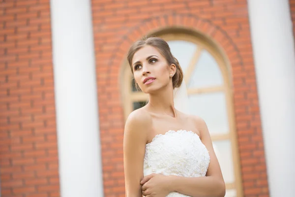 Braut vor Backsteinmauer-Hintergrund. Brautkleid — Stockfoto