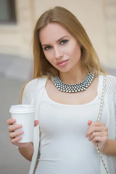 Stijlvolle vrouw drinken koffie te gaan in een stad straat — Stockfoto