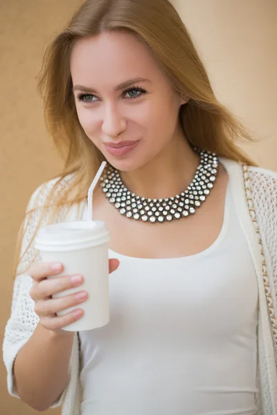 Stijlvolle vrouw drinken koffie te gaan in een stad straat — Stockfoto
