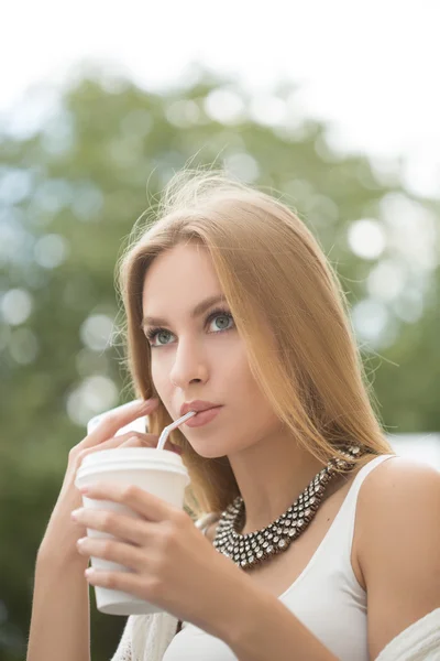 Stylish woman drinking coffee to go in a city street — Stock Photo, Image