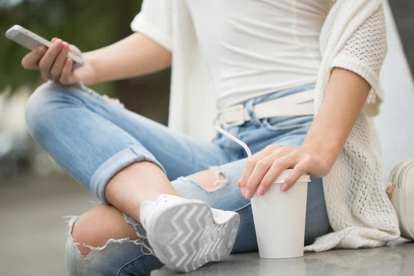 Stijlvolle vrouw drinken koffie te gaan in een stad straat — Stockfoto