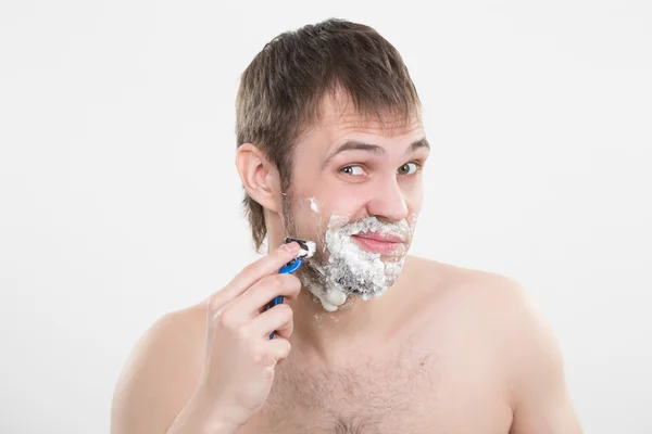 Knappe jonge man met een scheerschuim — Stockfoto