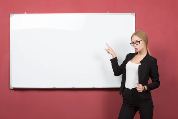 Mujer de negocios apuntando a la pizarra — Foto de Stock