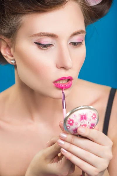 Sexy young pin-up girl doing make-up — Stock Photo, Image