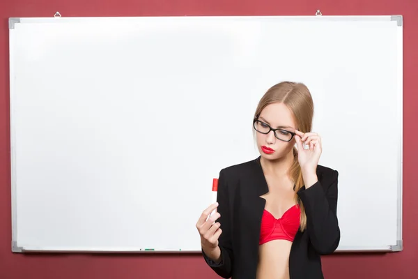 Girl with glasses and a bra on a background of white board — Stock Photo, Image