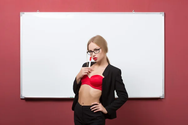 Girl with glasses and a bra on a background of white board — Stock Photo, Image