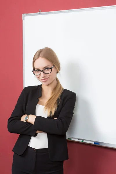 Mujer de negocios apuntando a la pizarra — Foto de Stock