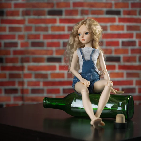 Docka med en flaska. begreppet alkoholism — Stockfoto