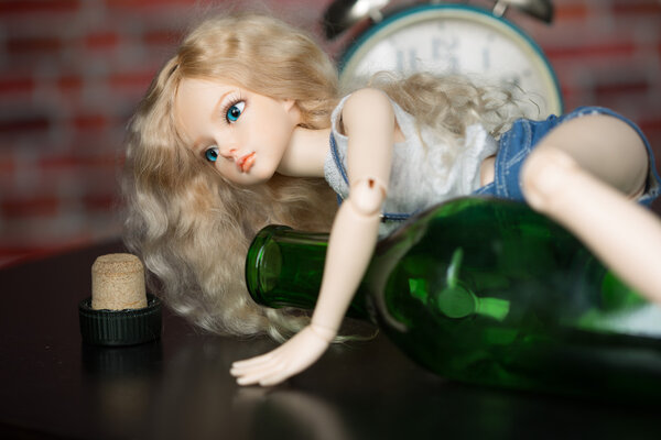 doll with a bottle. the concept of alcoholism