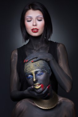 İki kız cadı altın süslemeli siyah boya. 