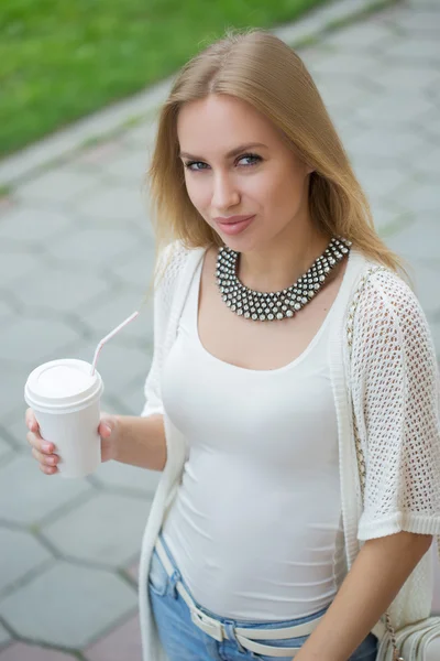 Stilvolle Frau trinkt Kaffee to go in einer Stadtstraße — Stockfoto