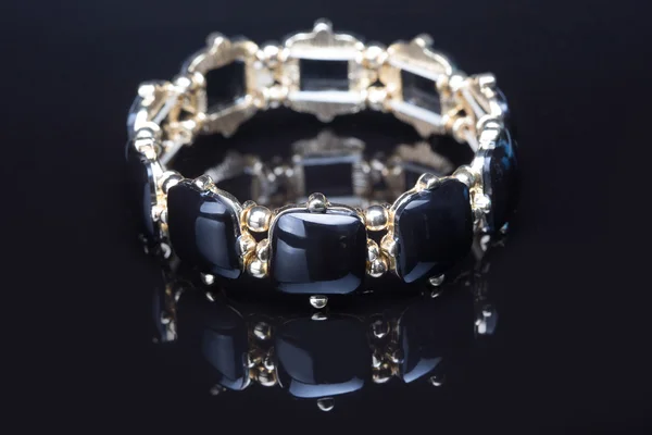 Pulsera con piedras negras sobre negro — Foto de Stock