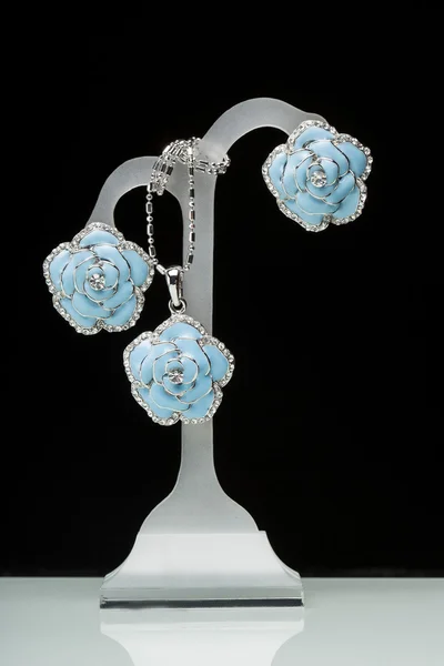 Earrings with blue stones on the black. flowers — Stock Photo, Image