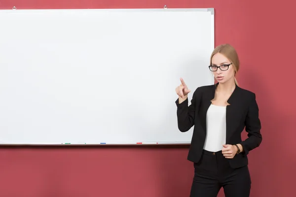 Chica de negocios muestra la mano índice en el banner en blanco —  Fotos de Stock