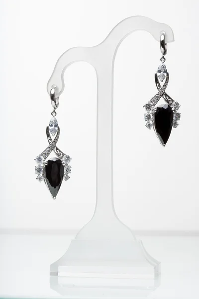 Earrings with black stones on the white — Stock Photo, Image