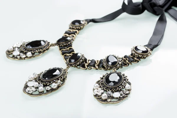 Black necklace with stones on white — Stock Photo, Image