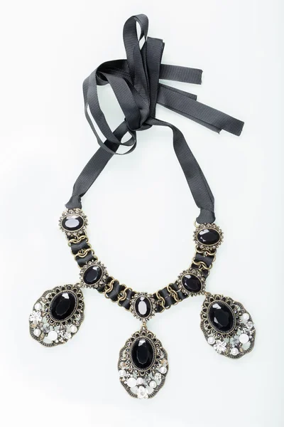 Černý náhrdelník s kameny na bílém pozadí — Stock fotografie