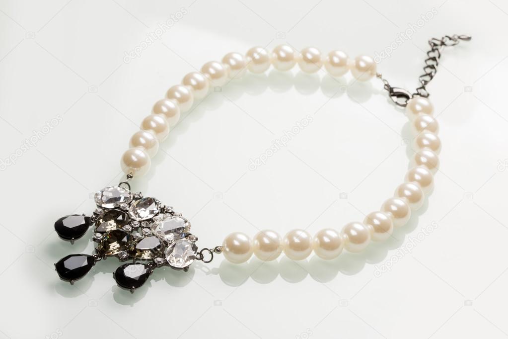 pearl necklace with black stones on a white 