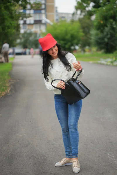 Gadis bertopi merah dengan telinga, memegang tas di jalan — Stok Foto