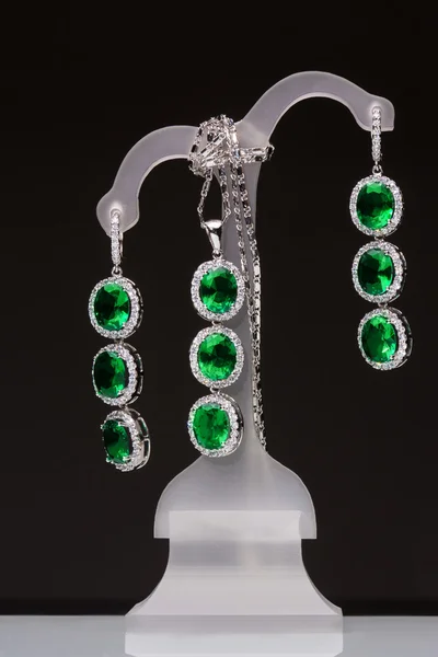 Earrings with green stones on a stand — Stock Photo, Image